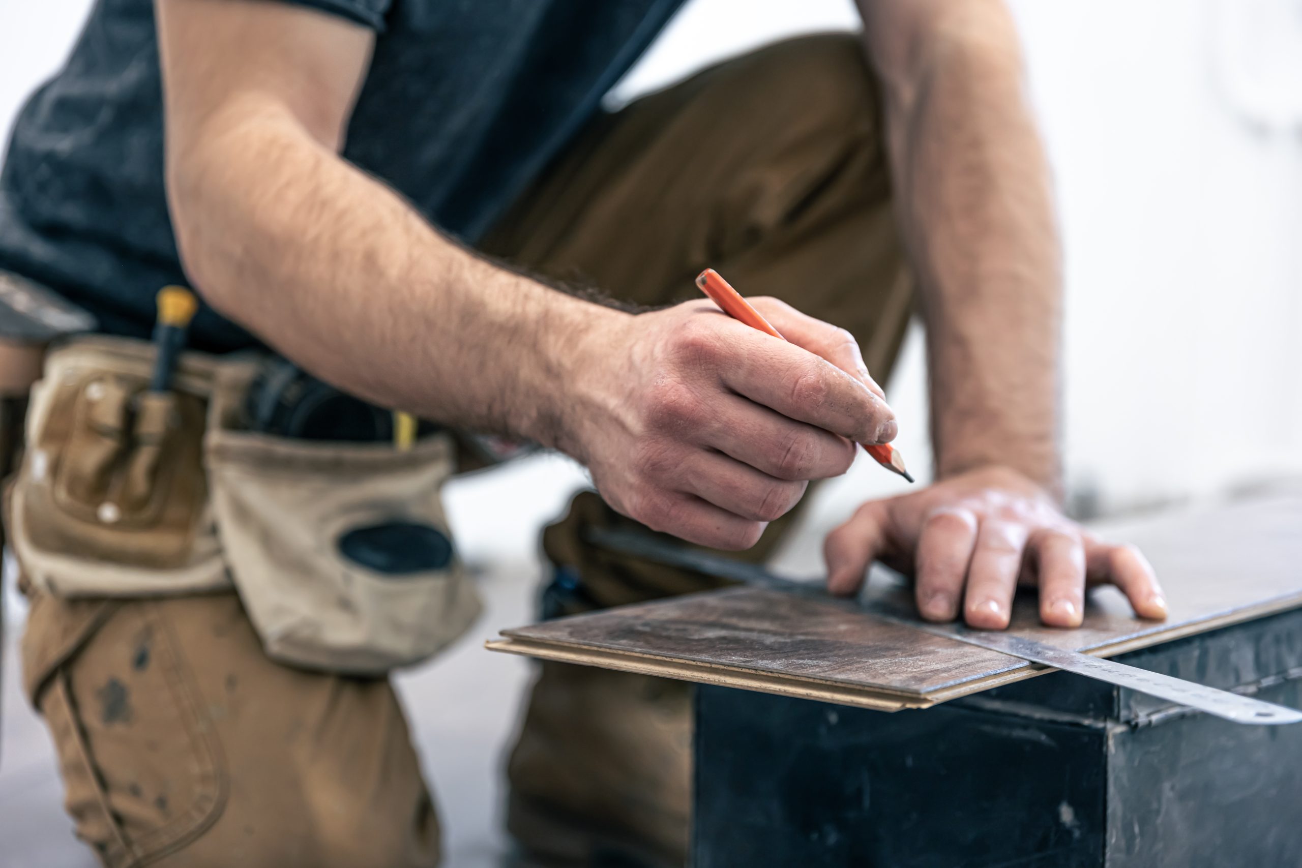 A male worker puts laminate flooring on the floor.